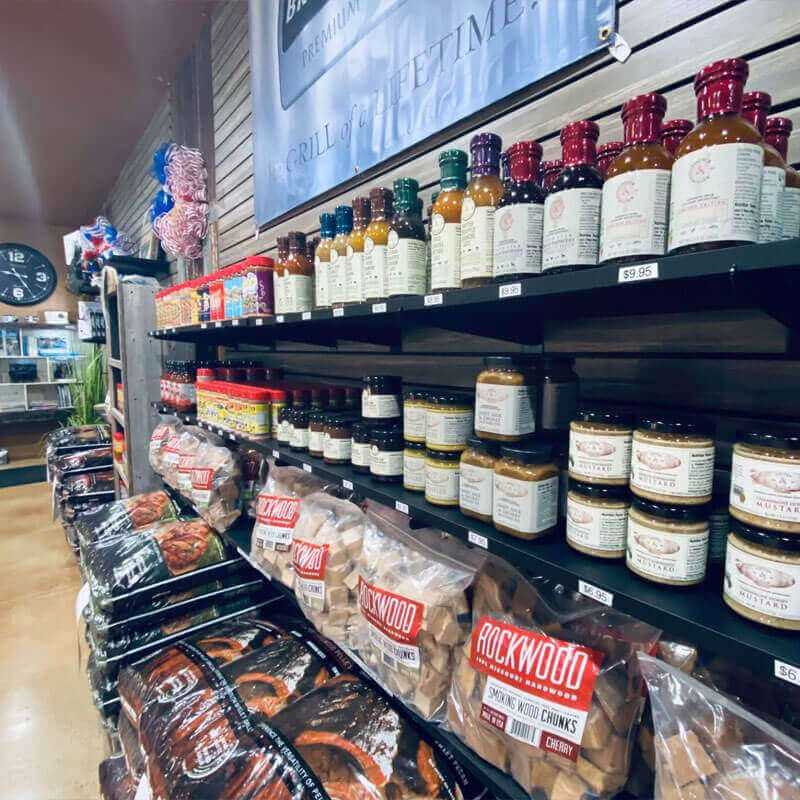 Hilltop Storage Solutions of Northlake offers a variety of grilling supplies. Image of shelves stocked with grilling sauces, rubs, and wood for grills.